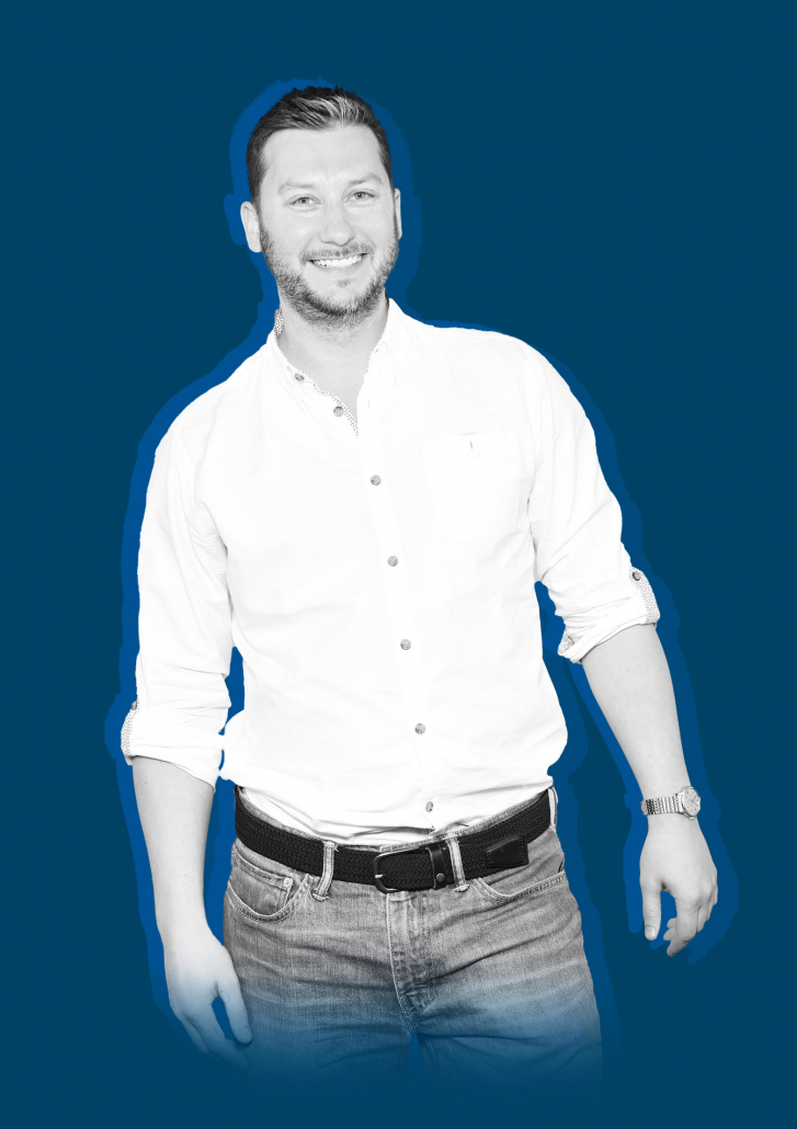 Andrew Kitchen wearing a white shirt against a blue background